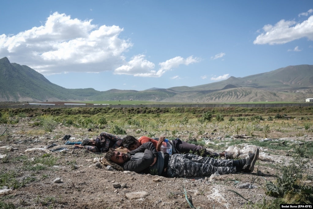 Tre afganë pushojnë pranë një autostrade afër qytetit lindor turk Bitlis, më 2 qershor. Ata udhëtuan nga Afganistani përmes Iranit, pasi luftimet në vendin e tyre u përshkallëzuan.