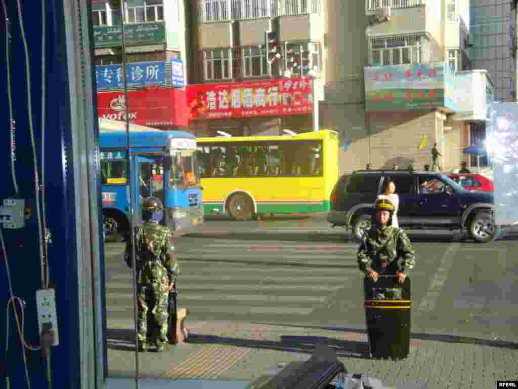 Китайские военные наблюдают за происходящим на улице. Урумчи, 11 июля 2009 года.