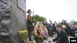 Acting Moldovan President Mihai Ghimpu adjusts the ribbon of a bouquet of flowers he placed at a Chisinau memorial to the victims of Soviet occupation and the totalitarian communist regime on June 28.