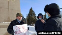Житель Уральска Бекболат Утепов разговаривает с сотрудником акимата, подошедшим к нему во время проведения одиночного пикета. 26 января 2021 года. 