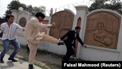 A supporter of former Pakistani President Pervez Musharraf kicks an anti-Musharraf lawyer outside a court in Rawalpindi on April 23.