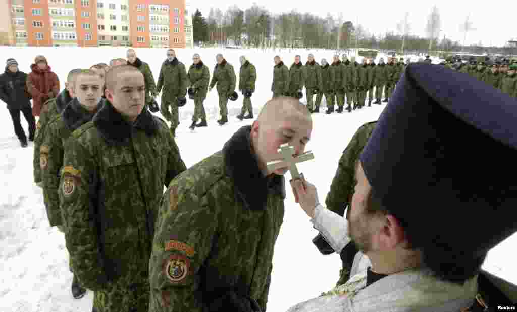 Belarusian Interior Ministry troops line up to kiss an Orthodox cross after a service at a military base in Minsk. (REUTERS/Vasily Fedosenko)