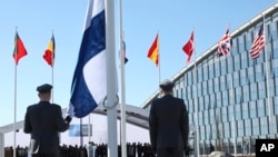 Katonák készülnek Finnország zászlajának felvonására a NATO külügyminiszteri találkozója alkalmából rendezett zászlófelvonási ünnepségen a NATO brüsszeli központjában 2023. április 4-én