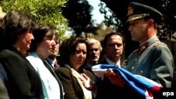 Главком Чейре передает национальный флаг дочерям генерала Карлоса Пратса. Пратс был вице-президентом Чили во времена Сальвадора Альенде. Он погиб в эмиграции через год после военного переворота