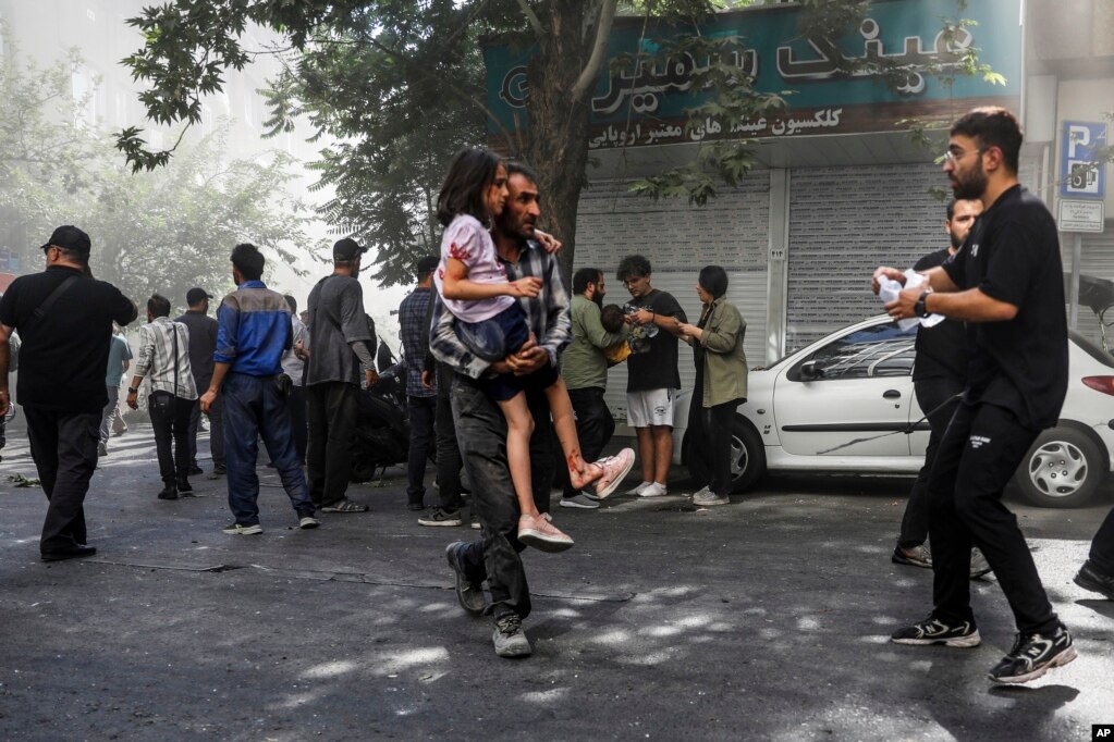 Një burrë e bart me nxitim një vajzë nga një vend ku kishte ndodhur një shpërthim në Teheran, gjatë sulmeve izraelite në kryeqytetin iranian, 15 qershor.