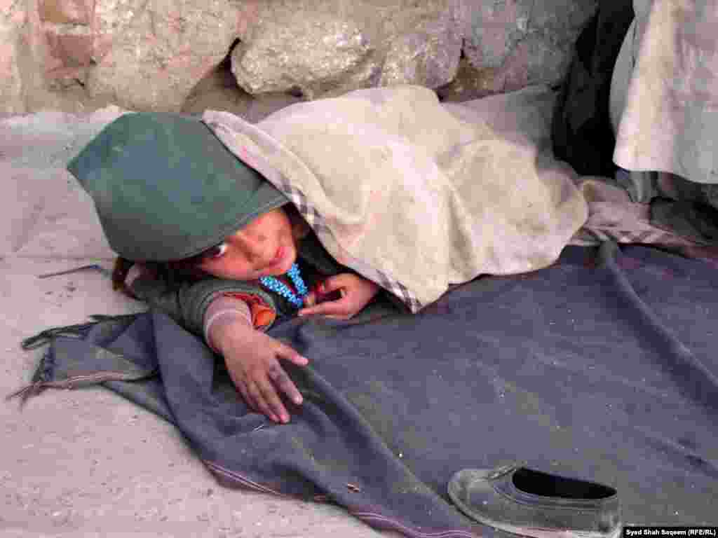 افغانستان: کندهار، یوه وړوکې افغان انجلۍ د سړک غاړې ته خیر غواړي.