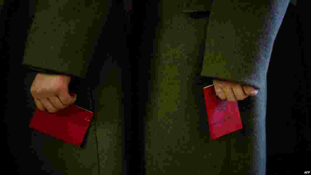 Soldiers hold their ID at a polling station in Moscow