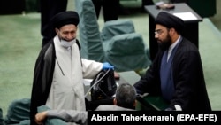 An Iranian lawmaker with an Oxygen box talks to his colleagues during a parliament session at the Iranian parliament in Tehran, May 28, 2020