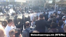Демонстрантите залепија постер „Криминална влада на Северна Македонија“ на штитовите на полицајците од кордот што го запре протестниот марш