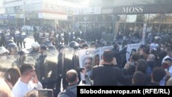 Демонстрантите залепија постер „Криминална влада на Северна Македонија“ на штитовите на полицајците од кордот што го запре протестниот марш