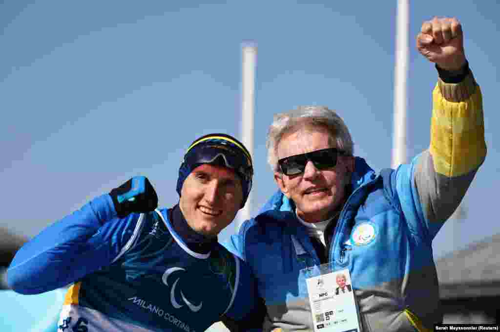 Парабіатлоніст Тарас Радь та президент Національного паралімпійського комітету України Валерій Сушкевич.Національний паралімпійський комітет повідомив також про ситуацію навколо родини Тараса Радя, яка приїхала на змагання підтримати спортсмена. Коли рідні чемпіона спробували потрапити на глядацьку трибуну змагань з біатлону, представники МПК відібрали у них українські прапори та хусточки з українським національним орнаментом. Заявивши, що «так робиться відповідно до правил МПК»