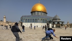 Snimatelj pada dok izraelski policajac trči za njim tokom sukoba s Palestincima u kompleksu u kojem se nalazi džamija Al-Aksa, koja je muslimanima poznata kao Plemenito utočište, a Jevrejima kao Brdo hrama, u Starom gradu u Jerusalimu, 10. maja 2021.