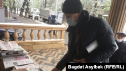 Активист Альнур Ильяшев покупает газету, которую отдаст сотрудникам службы пробации. Алматы, 22 апреля 2021 года

