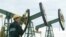 File picture shows a worker looking over the derricks at Yuganskneftegaz oil 