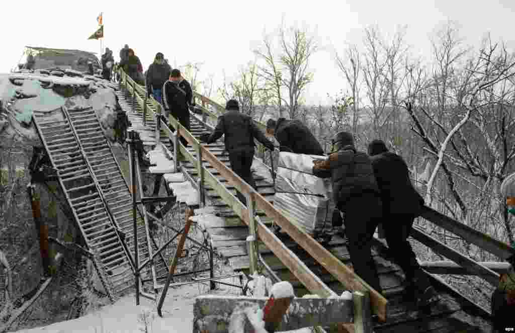 Люди тягнуть сумки на зруйнований міст через Сіверській Донець по дорозі від КПП бойовиків до української сторони, Станиця-Луганська, 16 грудня 2016 року