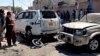 Local residents examine damaged vehicles at the site of a bomb blast in Chaman, southwestern Pakistan, on May 21.