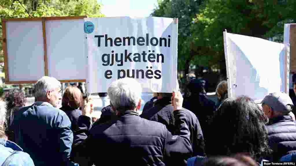 Jedan radnik, među desetinama demonstranata na trgu u Prištini, drži transparent kojim se zahtijeva osnivanje radnog suda.