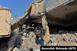 Сотрудник афганских служб безопасности осматривает жилой дом, который был разрушен в ходе вооруденного столкновения между правительственными силами и боевиками группы ИГ в Джелалабаде в феврале 2021 года