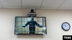 Russian opposition leader Aleksei Navalny is seen on a screen via a video link during a court hearing in June.