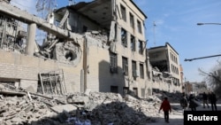 په تهران کې خلک د امریکا او اسراییلو په حملو کې د زیانمنو شویو ودانیو په خوا کې روان دي - د مارچ څلورمې انځور 