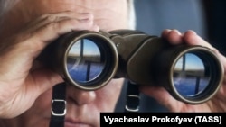 Президент Росії Володимир Путін у бінокль спостерігає за основним етапом військових навчань «Схід-2018» на полігоні «Цугол», 13 вересня 2018 року
