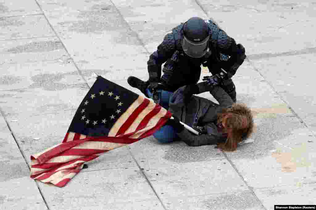 Një oficer policie arreston një protestues mbështetës të Trumpit, ndërsa turmat sulmuan ndërtesën e Kongresit, Uashington, janar 2021.