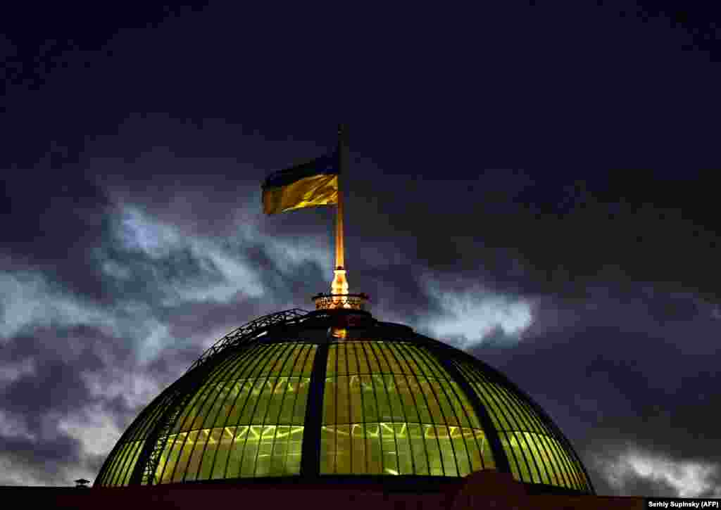 A Ukrainian flag flies in the wind on top of the parliament building in Kyiv. (AFP/Sergei Supinsky)