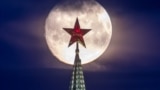 RUSSIA - The full moon is pictured behind the Vodovzvodnaya Tower of the Moscow Kremlin in Moscow, April 25, 2021