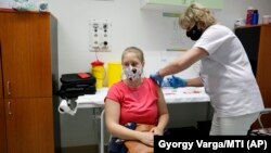 A nurse administers the Russian vaccine Sputnik V to a patient in a hospital in Nagykanizsa, Hungary.