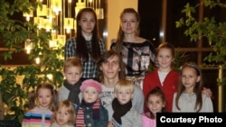 Екатерина Онохова (сверху справа) вместе с мужем Александром (в центре) и двумя собственными и семью приемными детьми. 2010 год.
