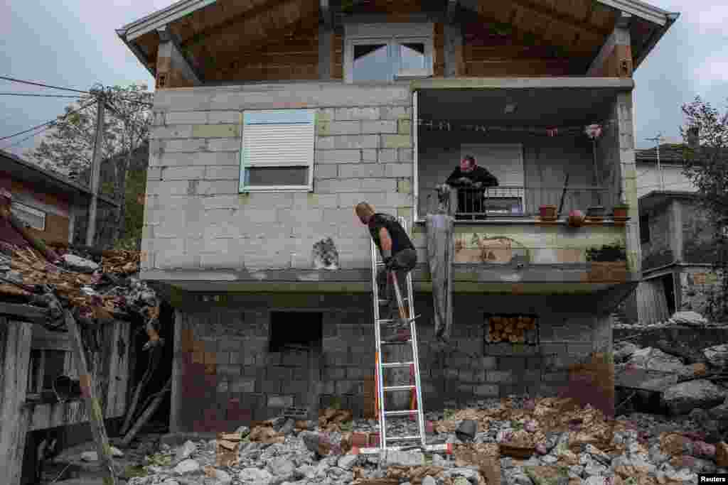 Banorët lokalë pastrojnë rrënojat nga një shtëpi në jug të Bosnjës më 5 tetor 2024.&nbsp;