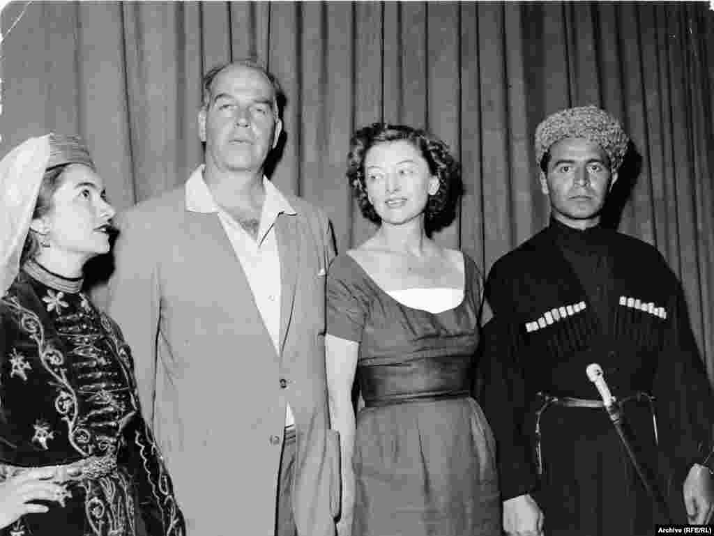 Radio Liberty employees relax in national dress at a retreat in Bavaria in the late 1950s. From left, Aza Ryzer, the head of the music library; Radio Liberty President Howland H. Sargeant; film star Myrna Loy, who was married to Sargeant; and Ibrahim Gelischanow, a founding member of the North Caucasus Desk.