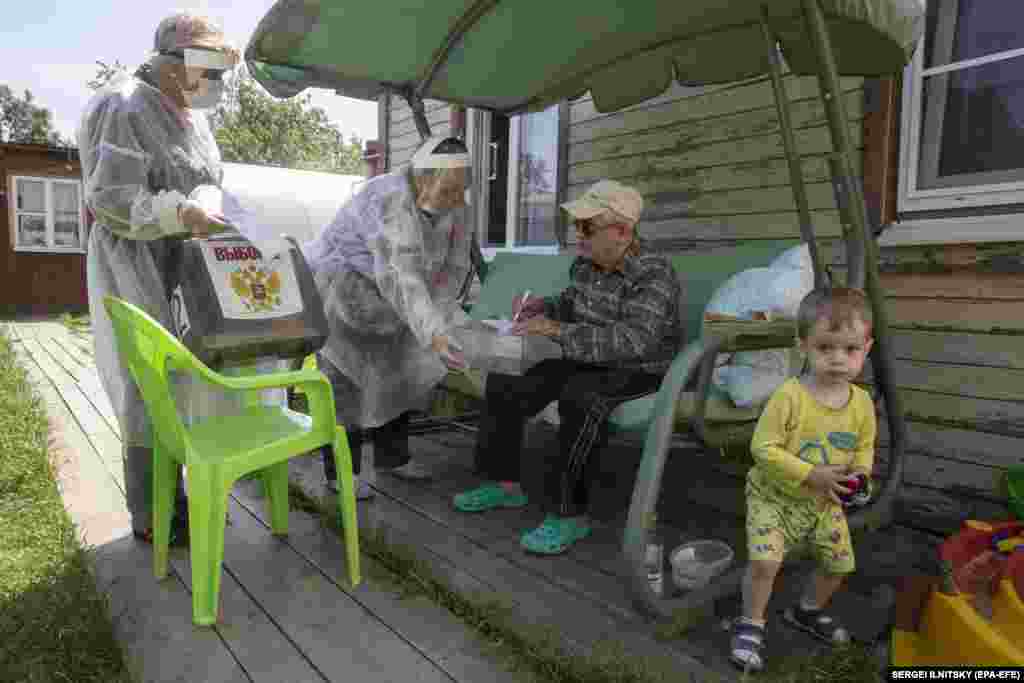 Mobile polling-station workers wear protective gear as they visit homes in the village of Vostryakovo outside Moscow.&nbsp;The vote has raised concerns among health officials as the number of new coronavirus infections in Russia remains stubbornly high at above 7,000 a day. &nbsp;