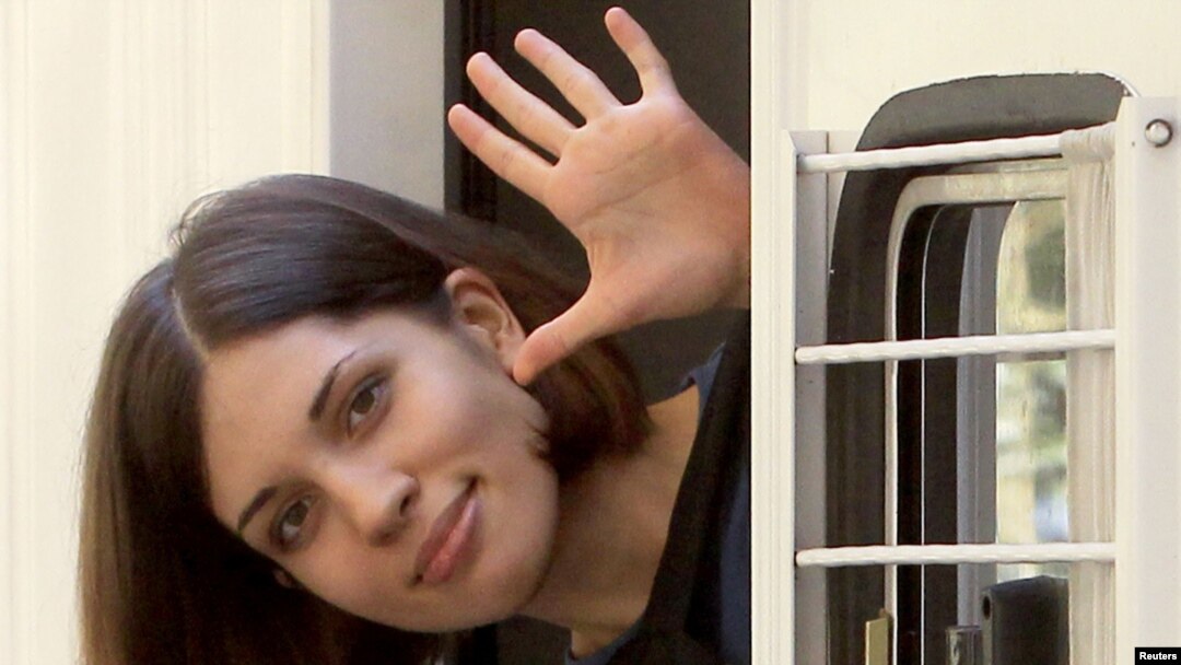 Nadezhda Tolokonnikova, a member of the feminist punk group Pussy Riot, waves from a police van after a court hearing in Moscow on August 8.