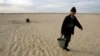 A Kazakh villager carries a bucket of water from a well in a desert that once formed the bed of the Aral Sea. (file photo)