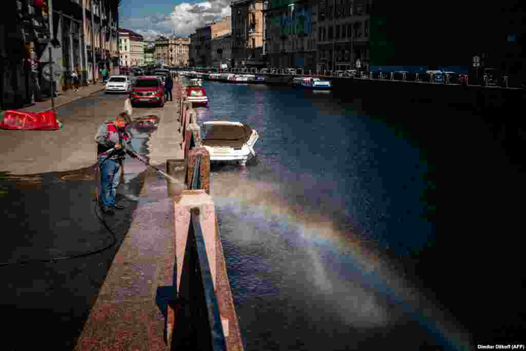 A Russian municipal worker cleans along an embankment of the Moika River in downtown St. Petersburg. (AFP/Dimitar Dilkoff)