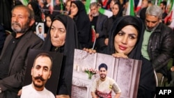 Тегерандагы мечитте өткөн эскерүү иш-чарасында жарандар “терроризмдин курмандыгы” деп жарыяланган маркумдардын сүрөтүн кармап турушат. 16-февраль, 2026-жыл.