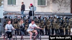 Tüntetők a rendőrök sorfala előtt biztosítják támogatásukról a bebörtönzött Navalnijt Habarovszkban, Moszkvától 6100 kilométerre 2021. április 21-én