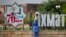 Уборщица на фоне городских украшений в честь 70-летия Ахмата Кадырова, архивное фото