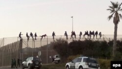 Disa migrantë duke tentuar të kalojnë në enklavën spanjolle, Melilla. Fotografi nga arkivi.