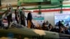 A handout picture released by the Iranian Presidency on August 21, 2018, shows President Hassan Rouhani (C) visiting the National Defence Industry exhibition in the capital Tehran. He inspected what Iran says is its homegrown fighter jet.