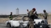 Afghan security forces inspect the exterior of a car after a suicide bomb blast in Gardez, Paktia Province on June 18.