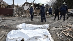 Emergency workers stand by bodies found in the rubble of a building hit during Russian drone strikes in Zaporizhzhia, Ukraine, on March 21.