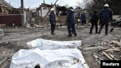 Emergency workers stand by bodies found in the rubble of a building hit during Russian drone strikes in Zaporizhzhia, Ukraine, on March 21.