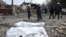 Emergency workers stand by bodies found in the rubble of a building hit during Russian drone strikes in Zaporizhzhia, Ukraine, on March 21.