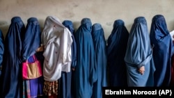Avganistanske žene čekaju da dobiju obroke hrane koje distribuira humanitarna grupa, u Kabulu, Avganistan, 23. maja 2023.