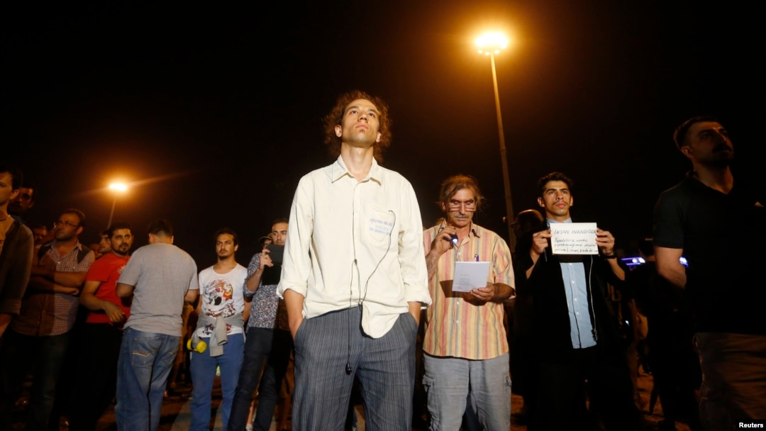 Erdem Gunduz (center) stands in silent protest on Taksim Square in Istanbul on June 18, staring up at an image of modern Turkey's founder, Kemal Ataturk.