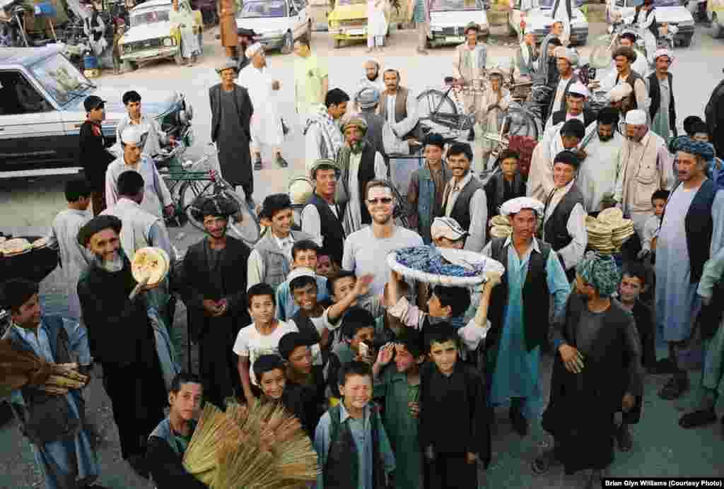 Me (in sunglasses) amid a smiling crowd of Afghans. I always received a warm welcome while traveling in northern Afghanistan and was regularly invited into people&#39;s humble homes as an honored guest where my hosts would offer me lamb or goat, often after slaughtering their only source of meat for the occasion.