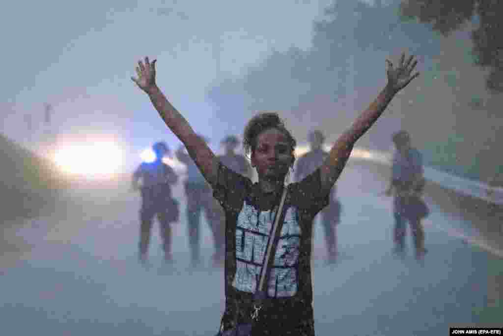 A protester is turned back by state troopers guarding an onramp to an interstate freeway near a Wendy's restaurant which was destroyed after being set fire at the scene of a 12 June Atlanta Police Department officer-involved shooting which left a black man dead at the restaurant in Atlanta, Georgia, USA, 14 June 2020.