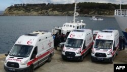 Disa ambulanca parkohen pranë një anije të rojës bregdetare turke në provincën Çanakala, ku raportohet se u mbytën së paku 20 emigrantë, 15 mars 2024.